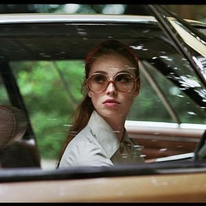 Foto Uma Dama de Óculos Escuros com uma Arma no Carro