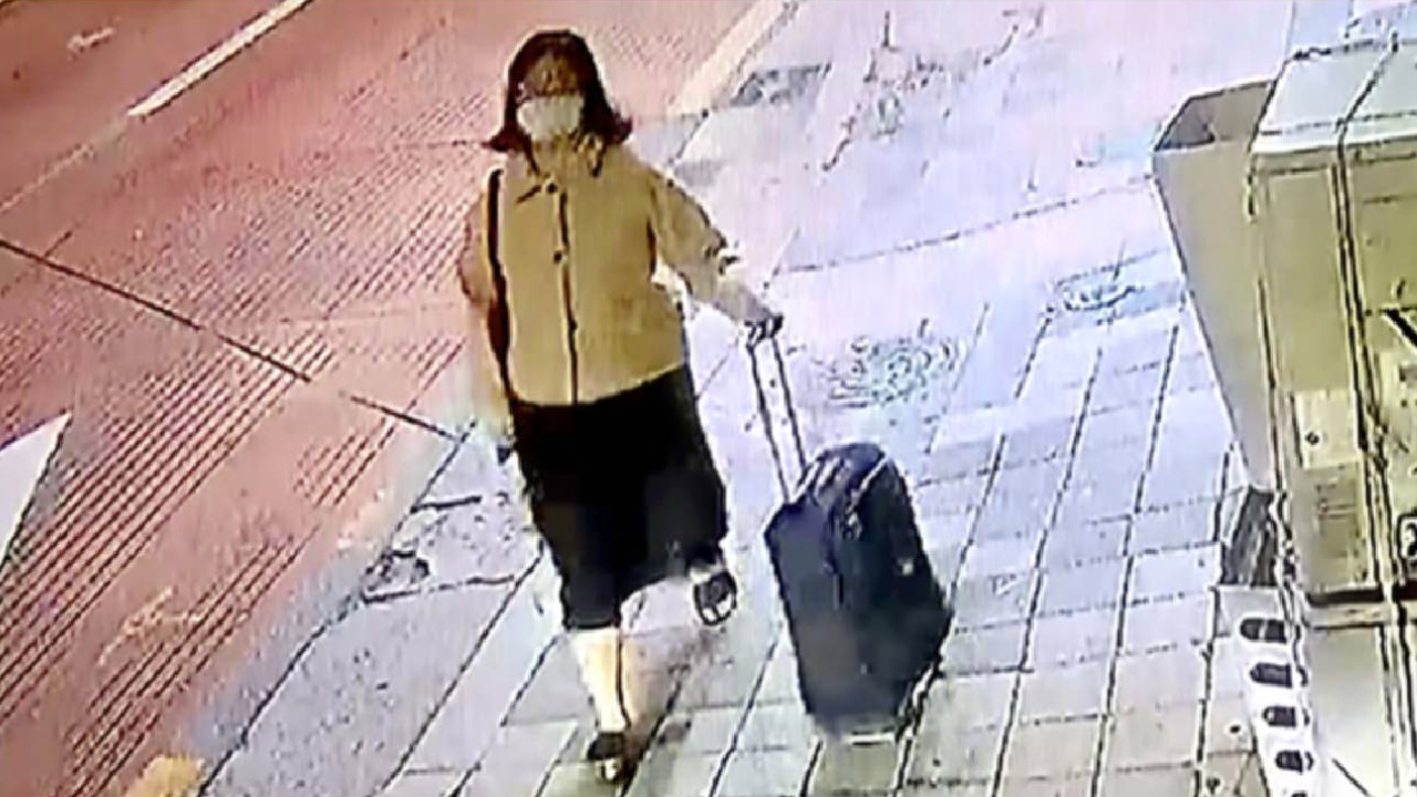 Jung Yoo-jung andando com a mala em que escondeu partes do corpo da vítima.